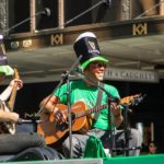 Two musicians wearing green and playing music on St. Patrick's Day
