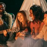 Group of Friends Sitting on Beach Sand playing music