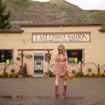young woman standing outside of The Last Chance Saloon