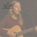 young woman singing and playing acoustic guitar