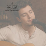 young musician playing guitar and singing into a microphone