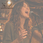 young woman singing joyfully into a microphone