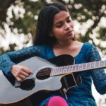 woman playing guitar outside