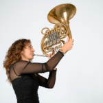 Female Musician Playing French Horn Solo