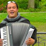 man playing accordion in a park