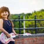 smiling young girl with a guitar