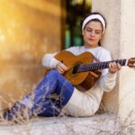 young woman playing a classical guitar