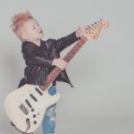 young boy playing electric guitar