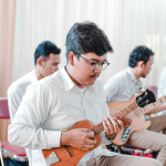 man playing a ukulele in an orchestra